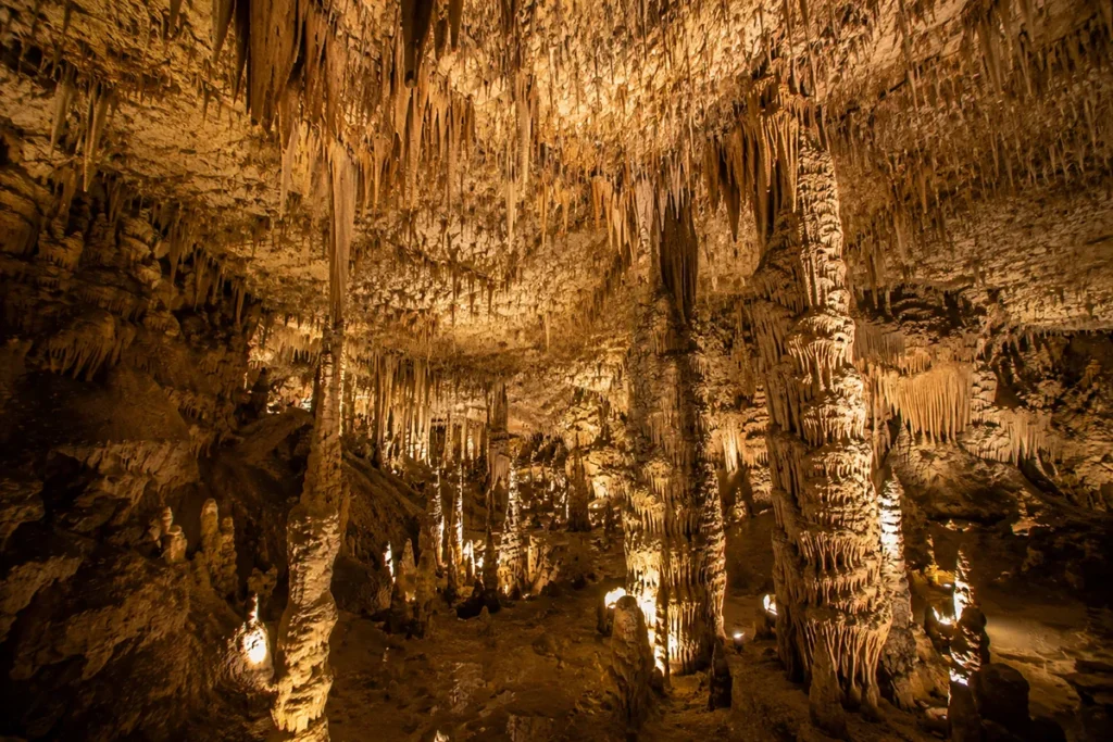 Limestone formations inside Lewis and Clark Caverns State Park in Montana, with stalactites, stalagmites, and a guided tour group walking through an illuminated chamber