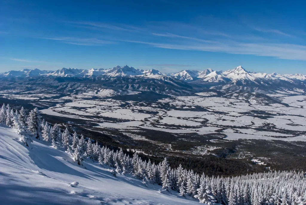 View from the top of Whitefish Mountain Resort looking east across the snow-covered Flathead Valley to the jagged peaks of Glacier National Park in the distance