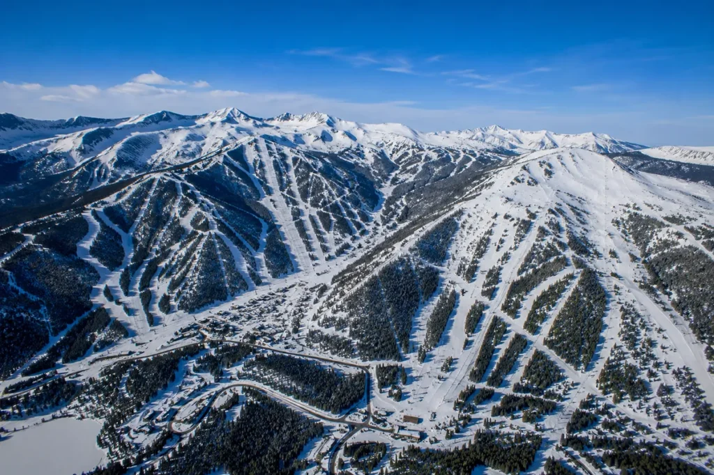 Wide aerial view showing the geographic relationship between Yellowstone Club, Big Sky Resort, and Moonlight Basin with the shared mountain terrain visible