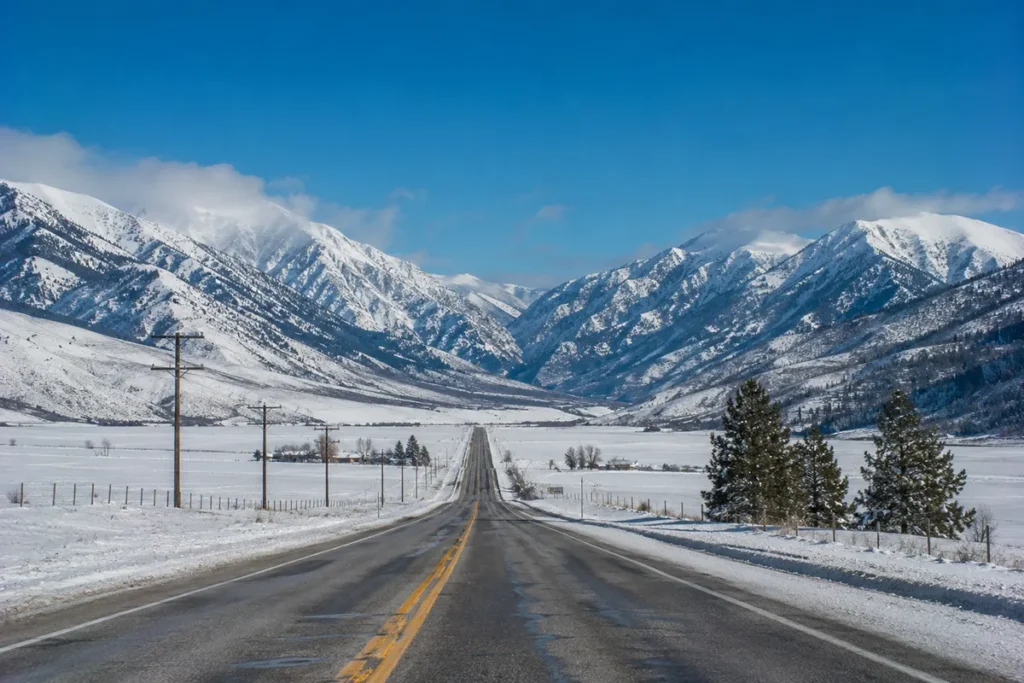 View south along US Highway 93 climbing through the Bitterroot Valley toward the Continental Divide with snow-covered Bitterroot Mountains rising on both sides of the road