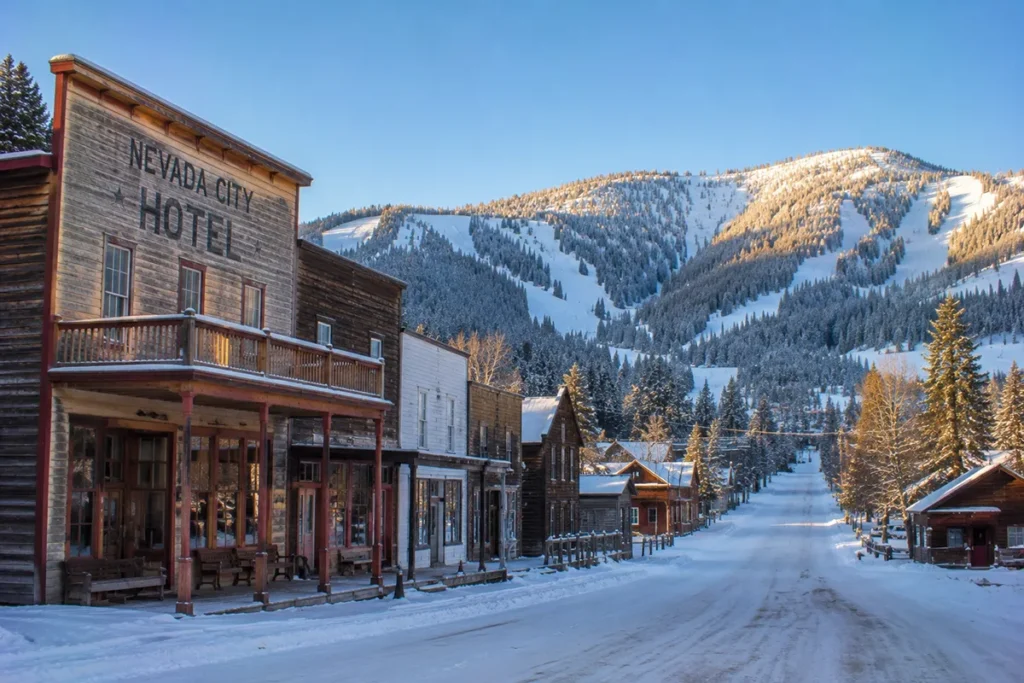 Snow-covered Marysville Montana with historic mining-era buildings and the road leading up to Great Divide Ski Area visible in the distance