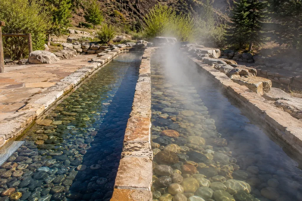Two parallel narrow Kneipp Walk pools with river rock bottoms showing the hot and cold water channels