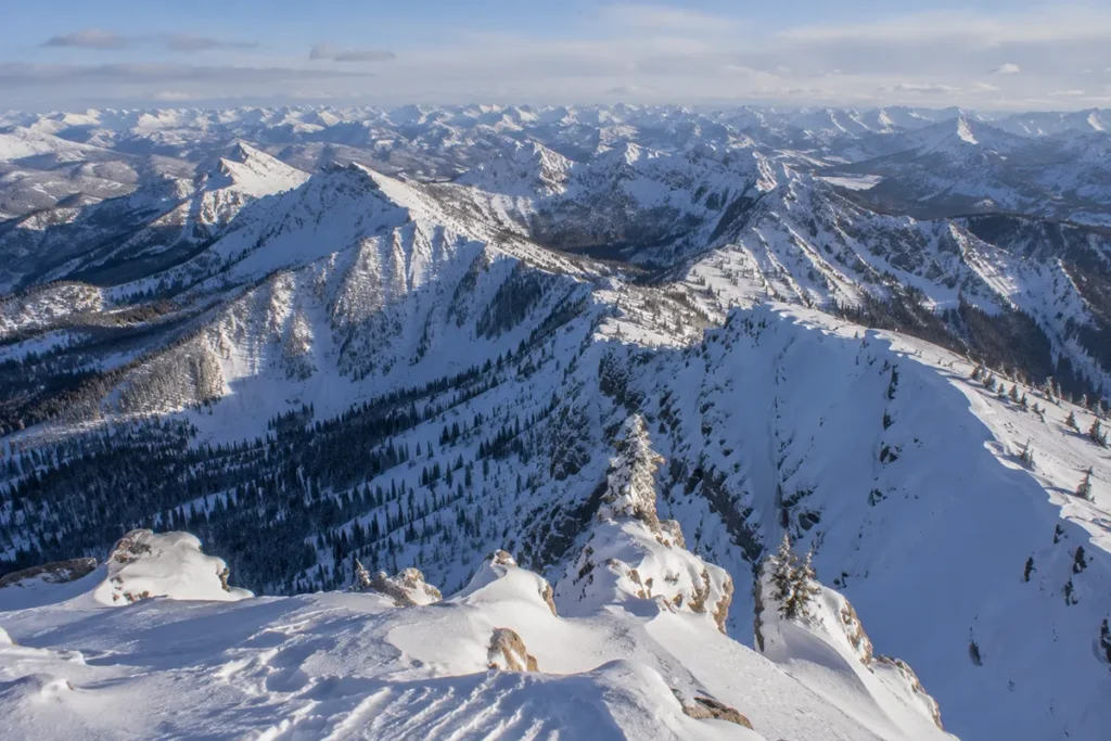 View from the top of the Teton Pass chairlift looking out across the Bob Marshall Wilderness with vast snow-covered wilderness terrain stretching to the horizon