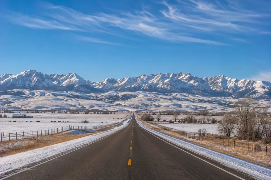View up Bridger Canyon Road from Bozeman with the Bridger Range rising in the distance covered in snow on a clear winter morning