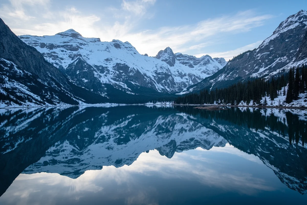 Alpine lake reflecting snow-capped Cabinet Mountains peaks in northwest Montana