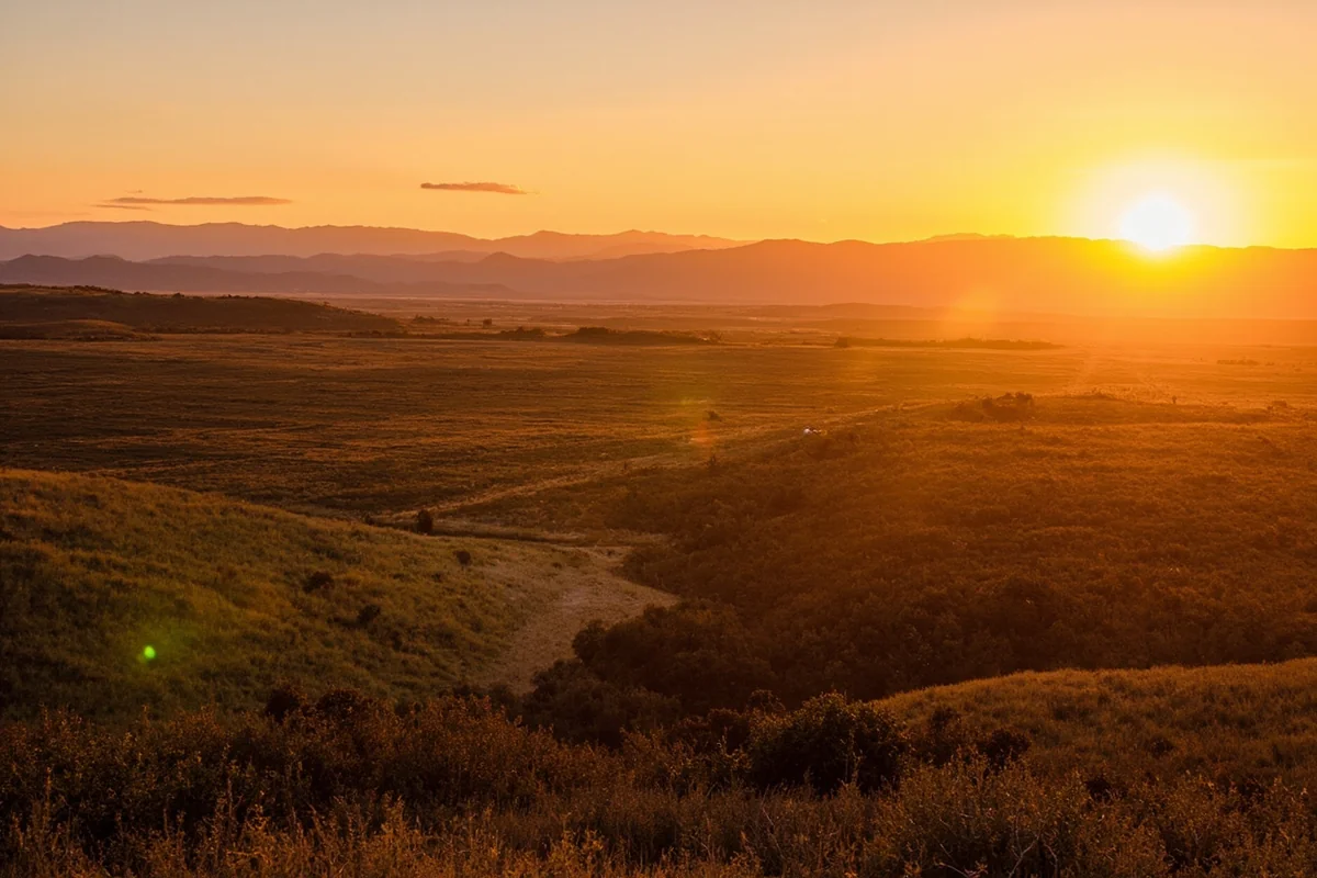 Flint Creek Valley at sunset with golden light on ranch land and mountains in distance
