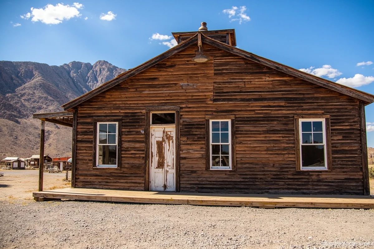 Miners Union Hall at Granite Ghost Town with weathered wood siding against mountain backdrop