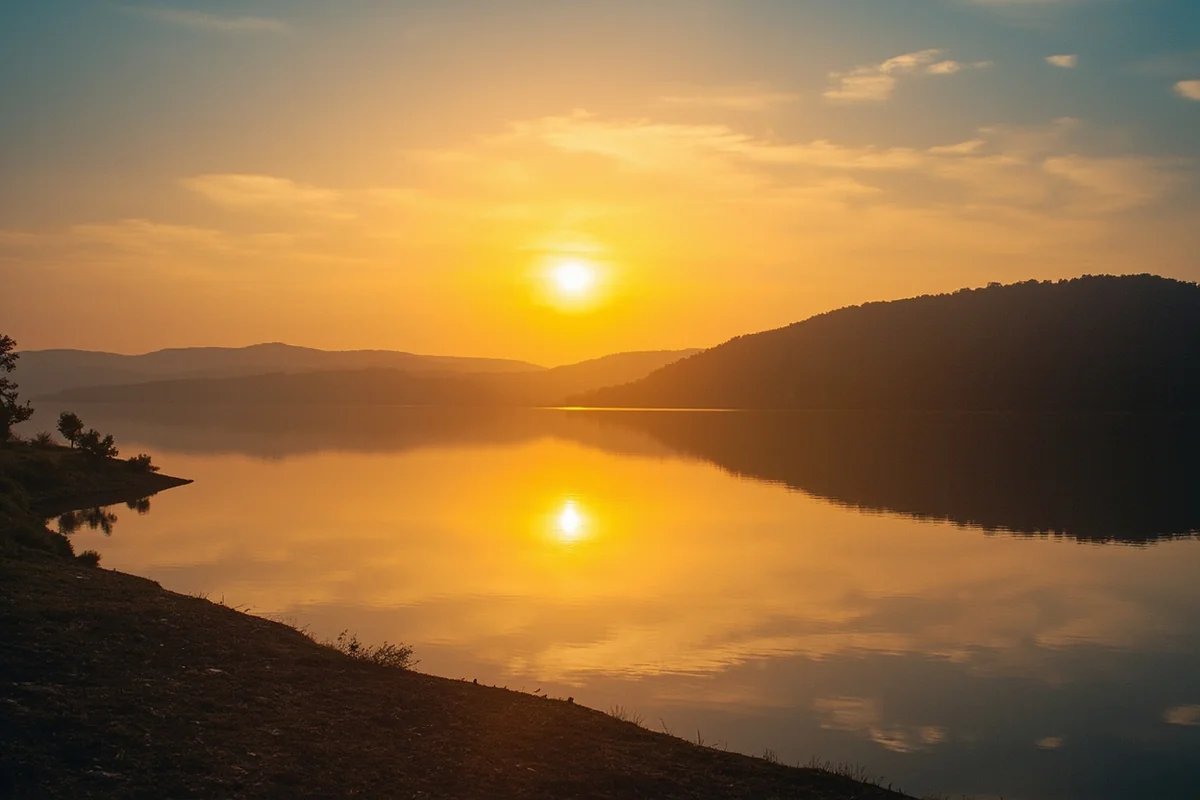 Sunrise over Lake Elwell (Tiber Reservoir) with calm water reflecting golden light