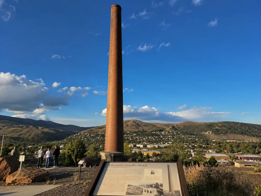 Anaconda Smoke Stack State Park showing the 585-foot brick smokestack against the Montana sky with interpretive signage visible