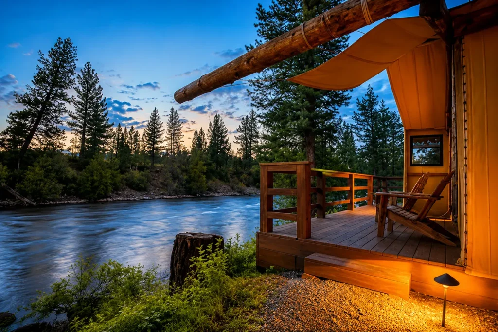 River Camp glamping tent at Paws Up Montana pitched on the bank of the Blackfoot River showing the luxury canvas tent with mountain backdrop