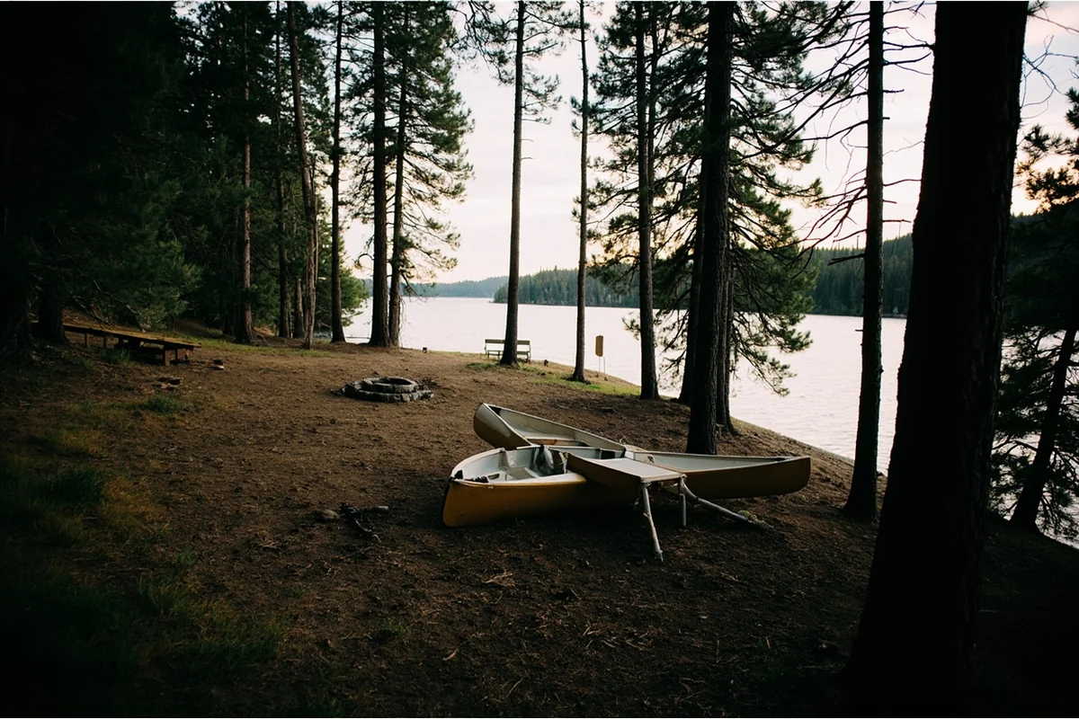 Rustic campsite along one of the Thompson Chain of Lakes with a canoe nearby