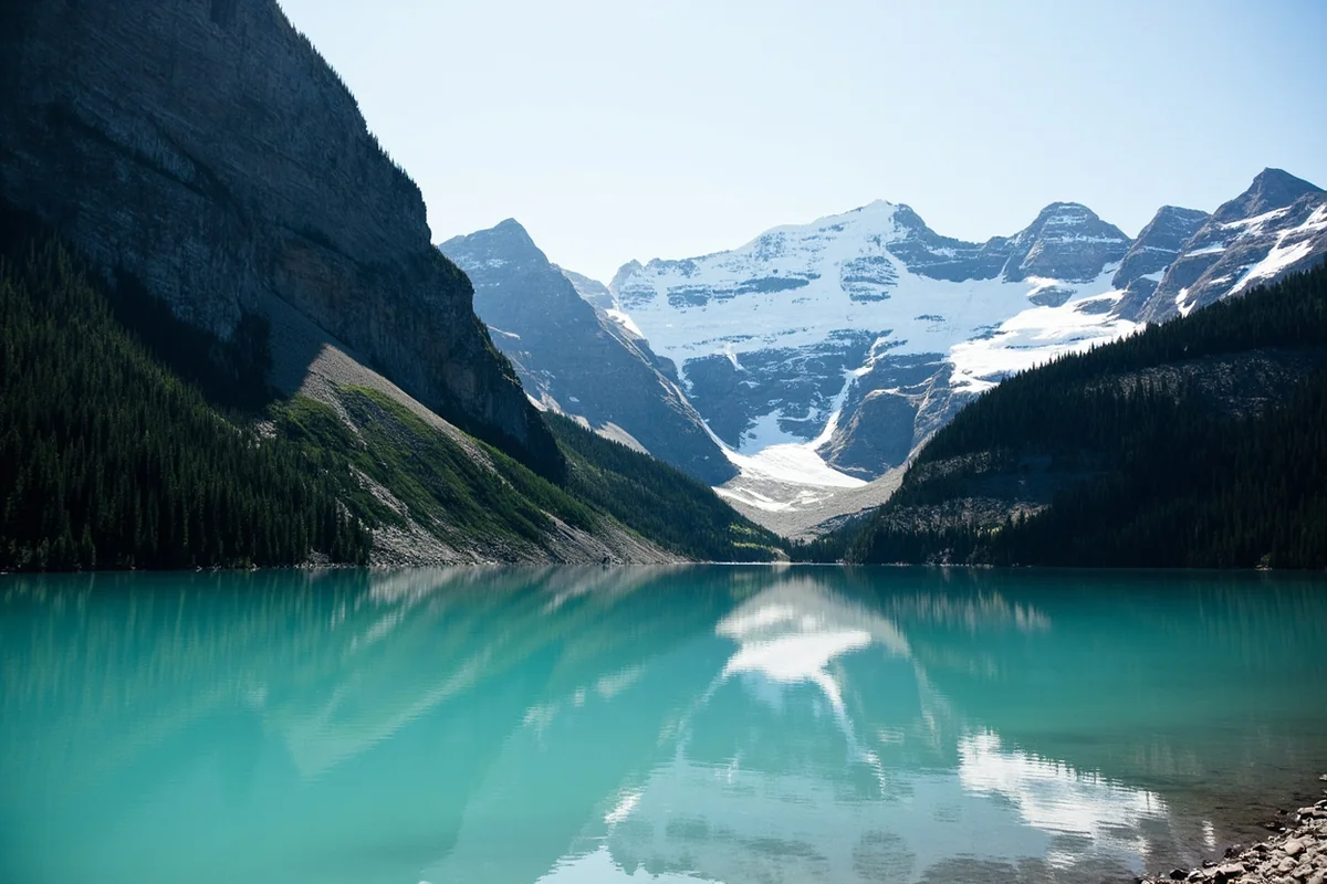 Turquoise water of Avalanche Lake with steep cliff walls on both sides