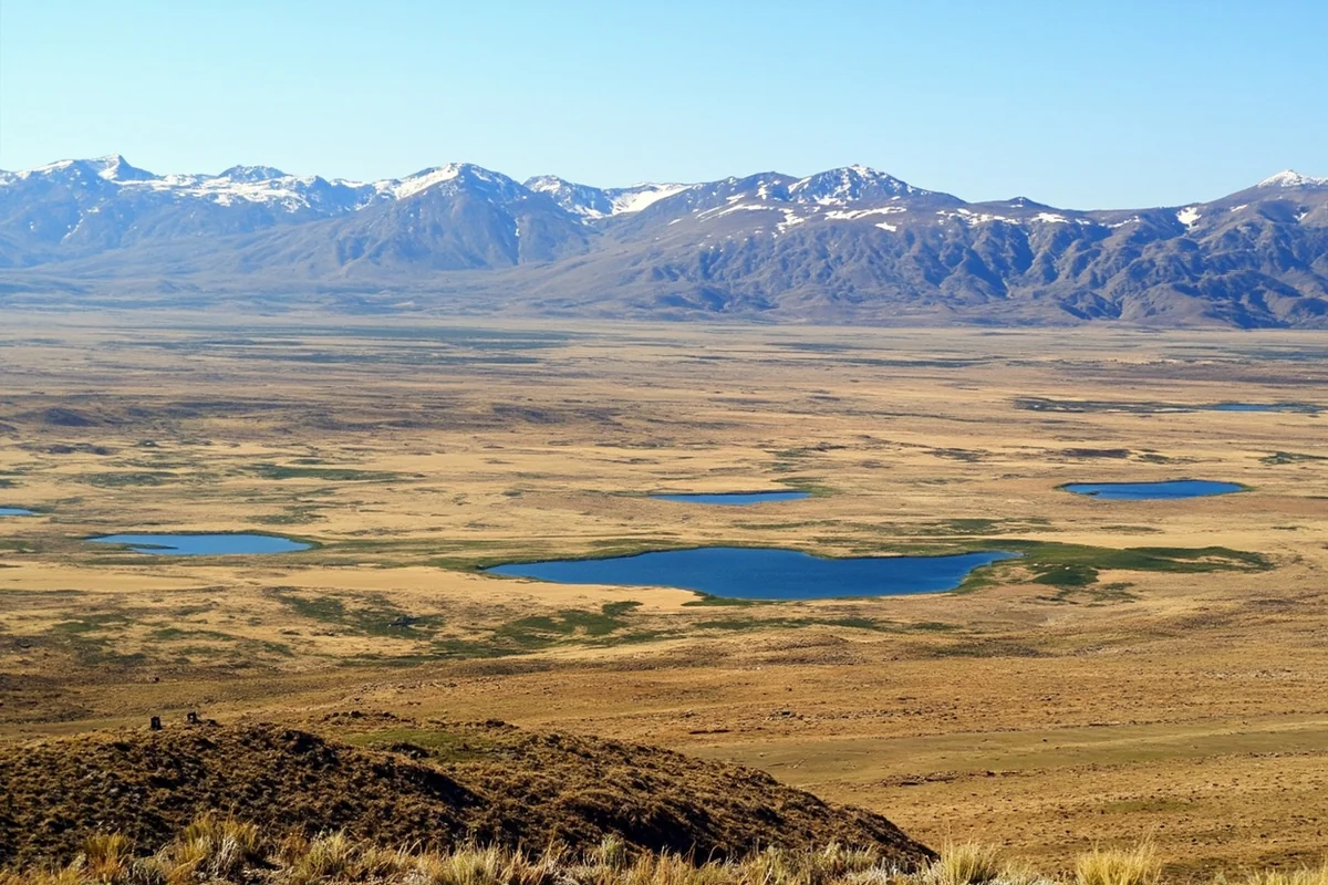 Wide view of the Beartooth Plateau's tundra basin with scattered lakes visible from above